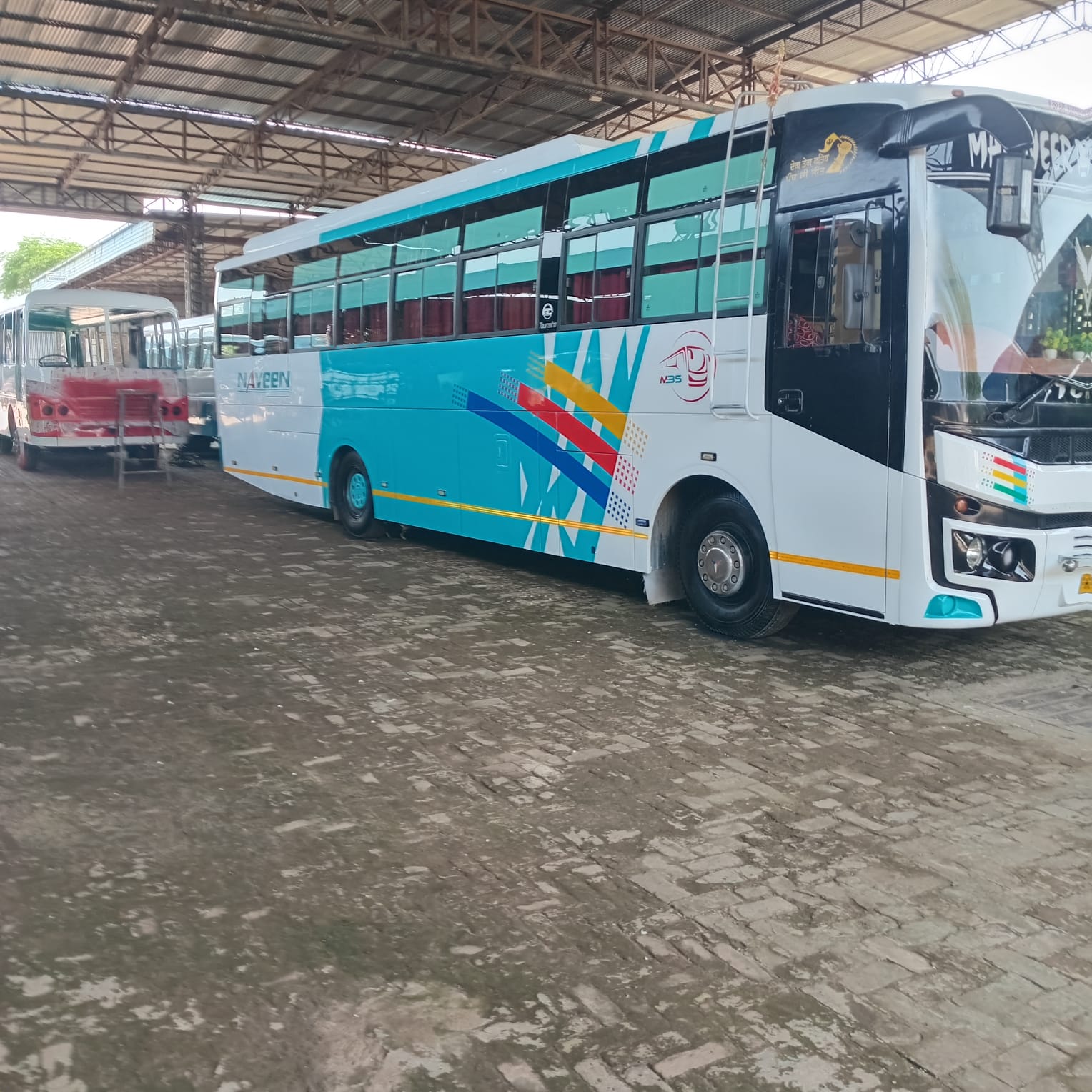 Teal and white coach parked at the depot